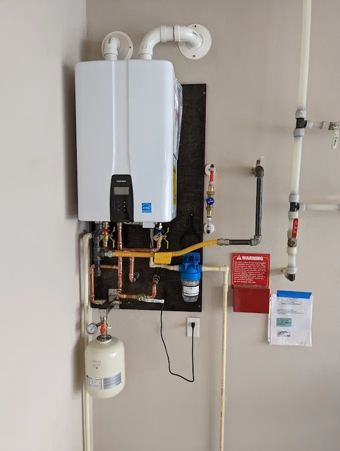 Professional plumber installing copper piping in a Bourne home